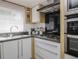 A kitchen with a sink and gas stove at Hedgerow Lodge near Haven Lakeside Grange-Over-Sands
