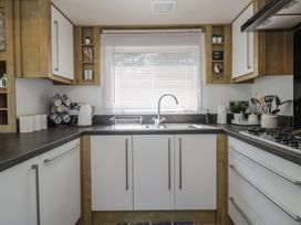 A kitchen with a sink and kettle at Hedgerow Lodge near Haven Lakeside