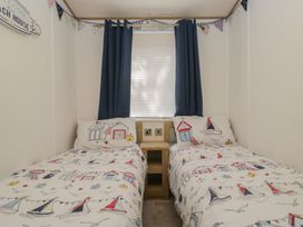 A bedroom with two beds and decorative pillows at Hedgerow Lodge Haven Lakeside near Grange-Over-Sands