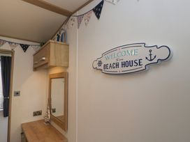 A bedroom with a mirror and welcome sign at Hedgerow Lodge, Haven Lakeside near Grange-Over-Sands