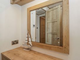 An entryway with a mirror and a sailing boat model at Hedgerow Lodge Haven Lakeside near Grange-Over-Sands