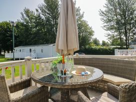 An outdoor dining area with a table and seating at Hedgerow Lodge near Haven Lakeside
