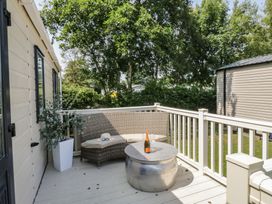 An outdoor area with a table and seating at Hedgerow Lodge near Haven Lakeside