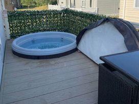 An outdoor space with a hot tub and tent at Tattershall Lakes Country Park - Holiday Accommodation 20875 Lincoln