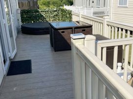 A deck area with a storage box and a hot tub at Tattershall Lakes Country Park - Holiday Accommodation 20875 Lincoln