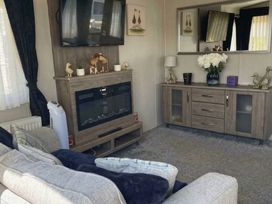 A living room with a sofa, television, and fireplace at Tattershall Lakes Country Park - Holiday Accommodation 20875, Lincoln
