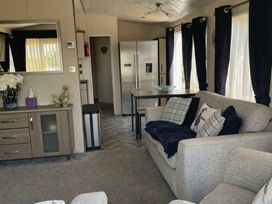 A living room with a sofa and refrigerator at Tattershall Lakes Country Park - Holiday Accommodation 20875 Lincoln