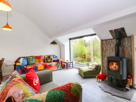 A living room with a sofa and a fireplace at Trwyn Cam in Brynrefail near Llanberis