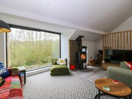 A living room with a wood stove and sofa at Trwyn Cam in Brynrefail near Llanberis