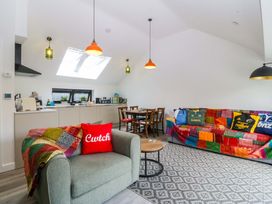 A living room with a couch and dining area at Trwyn Cam Brynrefail near Llanberis