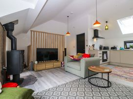 A living room with a sofa and television at Trwyn Cam in Brynrefail near Llanberis
