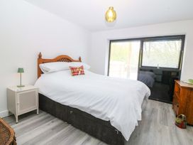 A bedroom with a bed and nightstand at Trwyn Cam in Brynrefail near Llanberis
