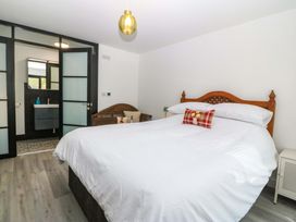A bedroom with a bed and access to a bathroom at Trwyn Cam in Brynrefail near Llanberis