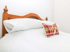 A bed with white linens and pillows at Trwyn Cam Brynrefail near Llanberis