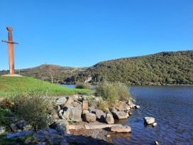 A metal sculpture beside water and rocks at Trwyn Cam in Brynrefail near Llanberis