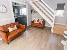 A living room with sofas and a staircase at The Wool Pack in Tenby