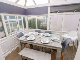 A dining table with tableware and chairs at The Wool Pack in Tenby