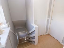 A staircase with a handrail and a door at The Wool Pack in Tenby