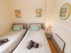 A bedroom with two single beds and a nightstand at The Wool Pack in Tenby