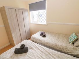 A bedroom with two beds and a wardrobe at The Wool Pack in Tenby