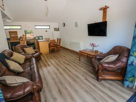 A living room with a sofa and dining area at Brookview Kingfisher in Haverfordwest
