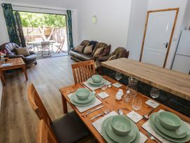 A dining room with a table set for dinner and a sofa at Brookview Kingfisher in Haverfordwest