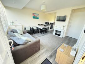 A living room with a sofa and dining table at Chalet 62 in California, Norfolk
