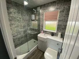 A bathroom with a shower, toilet, and sink at Chalet 57 California, Norfolk