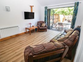 A living room with a television and sliding door at Brookview Goldfinch in Haverfordwest
