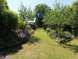 A garden with a pathway and flowers at Brookview Goldfinch in Haverfordwest