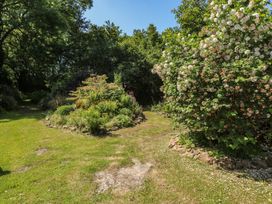 A garden with a pathway and various plants at Brookview Goldfinch in Haverfordwest