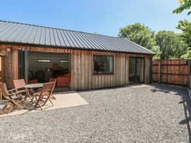 An outdoor area with a wooden building and a table with chairs at Brookview Goldfinch in Haverfordwest