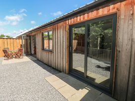 A wooden building with a sliding door and outdoor seating at Brookview Goldfinch Haverfordwest