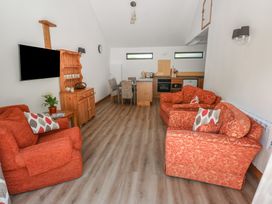 A living room with a television and dining area at Brookview Goldfinch in Haverfordwest