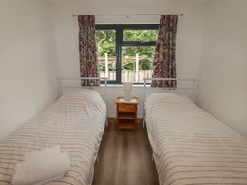 A bedroom with two beds and a nightstand at Brookview Goldfinch in Haverfordwest