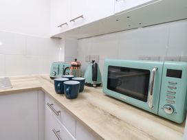 A kitchen with a microwave kettle toaster and cups at NO 10 Fortuneswell
