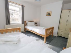 A bedroom with two beds and a wardrobe at NO 10 in Fortuneswell