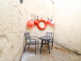 A seating area with a table and chairs in an outdoor space at NO 10 Fortuneswell