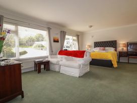 A bedroom with a bed and armchair at Tregoning annex in Lerryn near Lostwithiel