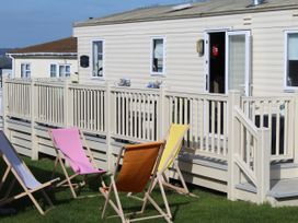 A holiday home with chairs on the patio at Kent Coast Holiday Park - Holiday Accommodation 22252, Rochester, Kent