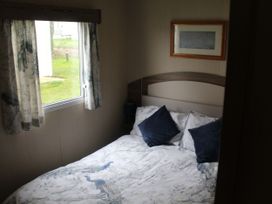 A bedroom with a double bed and a window at Kent Coast Holiday Park - Holiday Accommodation 22252, Rochester, Kent