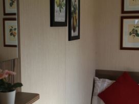 A bedroom with framed artwork on the wall and a bed at Kent Coast Holiday Park - Holiday Accommodation 22252, Rochester, Kent