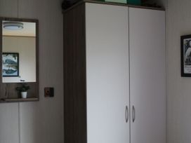 A wardrobe and mirror in a bedroom at Kent Coast Holiday Park - Holiday Accommodation 22252, Rochester, Kent