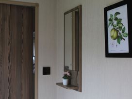 A hallway with a mirror and potted plant at Kent Coast Holiday Park - Holiday Accommodation 22252, Rochester, Kent