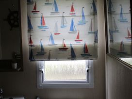 A bathroom with a window and sailboat patterned blinds at Kent Coast Holiday Park - Holiday Accommodation 22252, Rochester, Kent