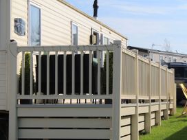 A caravan with decking and furniture at Kent Coast Holiday Park - Holiday Accommodation 22252, Rochester, Kent
