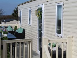 A deck with seating and plants at Kent Coast Holiday Park - Holiday Accommodation 22252 in Rochester, Kent