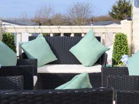 An outdoor seating area with black furniture and green cushions at Kent Coast Holiday Park - Holiday Accommodation 22252, Rochester, Kent