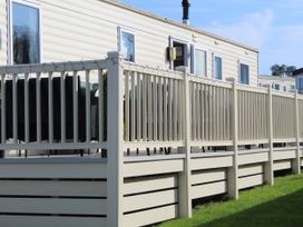 An outdoor area with a fence and seating at Kent Coast Holiday Park - Holiday Accommodation 22252, Rochester, Kent