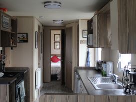 A kitchen with cabinets, sink, and stove at Kent Coast Holiday Park - Holiday Accommodation 22252, Rochester, Kent